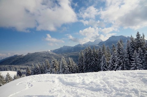 View from the peak of Mt Schwarzenberg to a snow-covered alpine upland and the Wendelstein Range