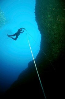 Freediver descending to a cave