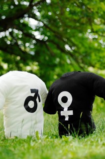 Two T-shirts with the symbols of Mars and Venus on a meadow