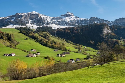 Green pastures in Appenzellerland in front of the snow-capped Appenzell Alps