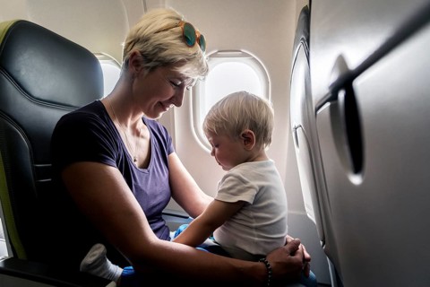 Mother with baby playing in a passenger airplane
