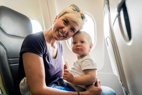 Mother with baby playing in a passenger airplane