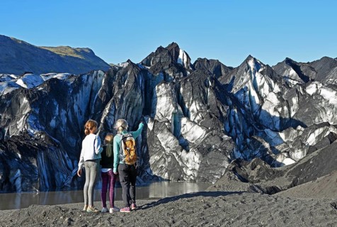 Mother with two children looks at the Solheimajokull glacier
