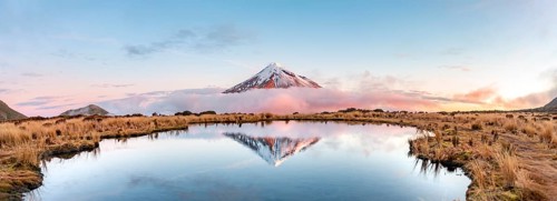Water reflection in Pouakai Tarn Mountain Lake at sunset