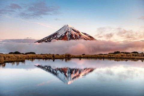 Water reflection in Pouakai Tarn Mountain Lake at sunset