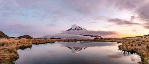 Water reflection in Pouakai Tarn Mountain Lake at sunset