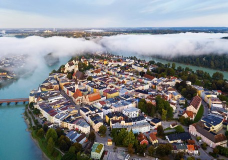 Old town in river bend of the Inn at dawn and fog