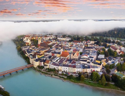 Old town in river loop of the Inn at dawn and fog