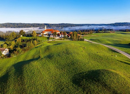 Hilly cow pasture and Reutberg Monastery