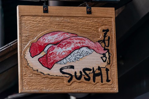 Signboard with inscription Sushi in front of a restaurant