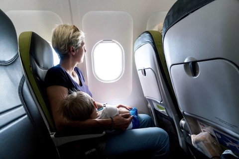Mother with sleeping baby in a passenger airplane