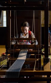 Japanese young woman weaving at the loom
