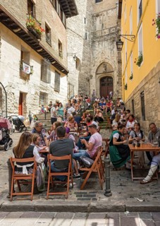 People eating in a street restaurant in front of Church of San Miguel