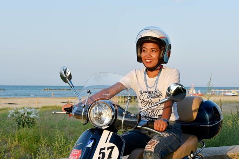 Woman on Vespa 125 Primavera in the port of Penelope