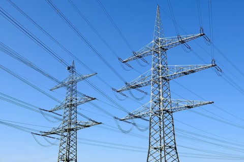 High-voltage pylons in front of a blue sky