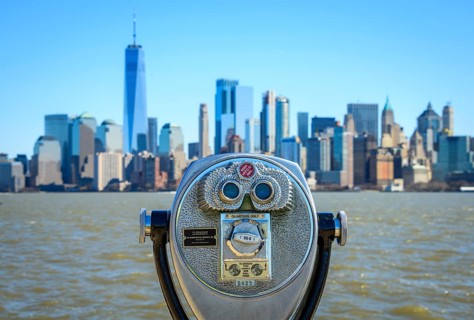 Telescope on Ellis Island overlooking the skyline of Lower Manhattan with skyscrapers