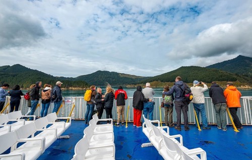 Passengers on deck of a ferry in the fjord