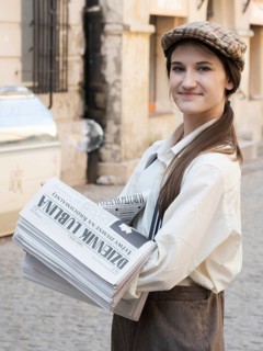 Historically dressed newspaper saleswoman