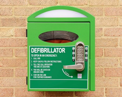 Automated external defibrillator mounted on the wall of a village hall