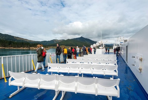 Passengers on deck a ferry in the fjord