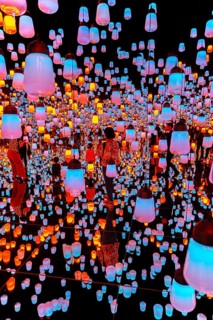 Visitors in the middle of a light installation with brightly lit lamps