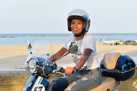 Woman on Vespa 125 Primavera in the port of Penelope