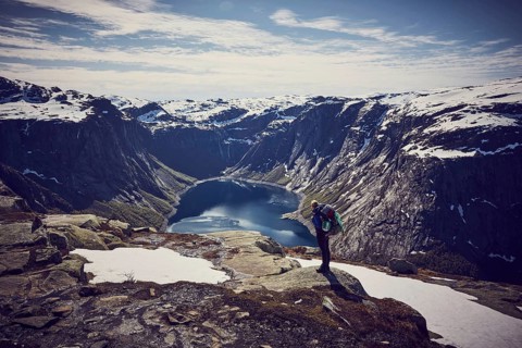 Young woman climbing to Trolltunga