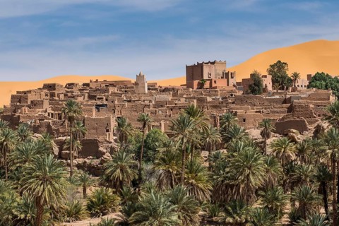 Overlook over the oasis of Taghit with sand dunes