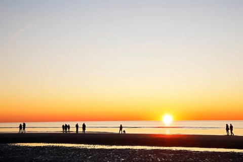 People on the beach at sunset over the North Sea