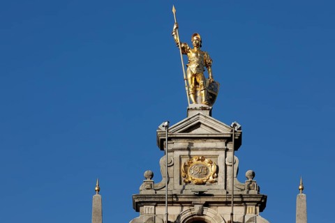 Golden figure with lance on gable of a guild house
