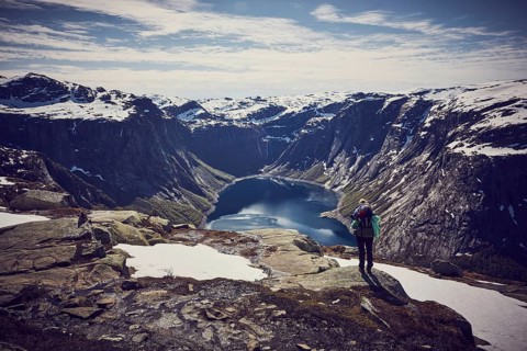 Young woman climbing to Trolltunga