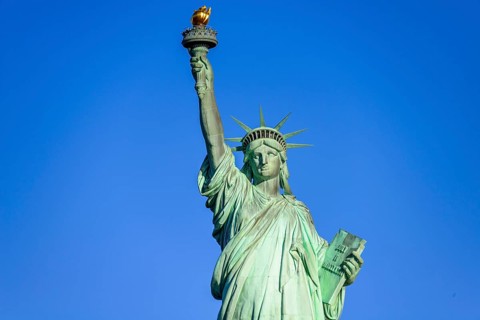 Statue of Liberty in front of blue sky