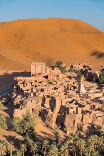 Overlook over the oasis of Taghit with sand dunes