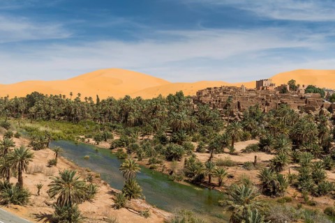 Overlook over the oasis of Taghit with sand dunes