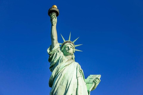 Statue of Liberty in front of blue sky