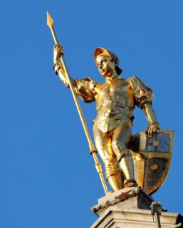 Golden figure with lance on gable of a guild house