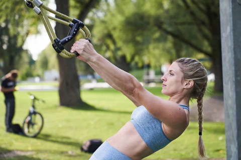 Sporty young woman doing fitness training on the rings