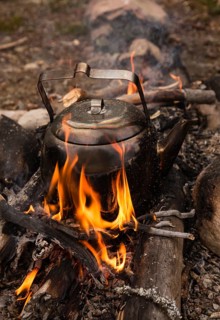 Large sooty coffee kettle on campfire
