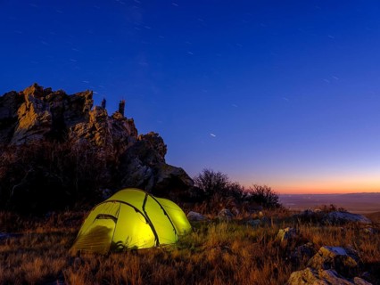Tent under a rock at dusk