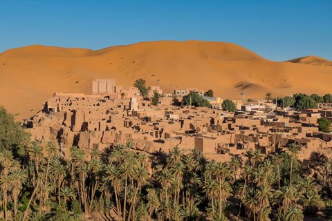 Overlook over the oasis of Taghit with sand dunes