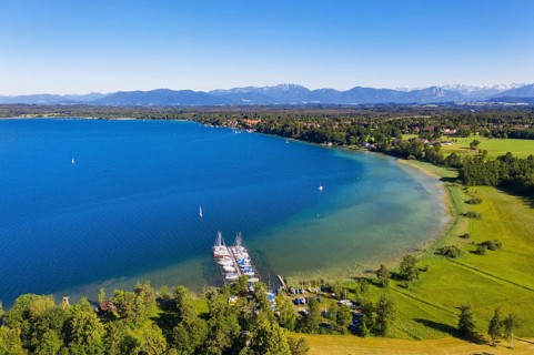 Boat landing stage in lake sides at Lake Starnberger See with alpine chain