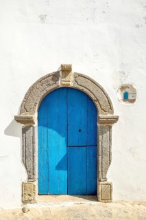 White house wall with blue wooden door