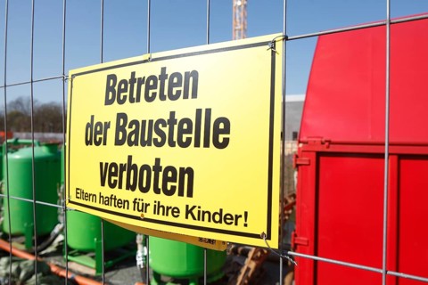 Yellow sign: No one is allowed to enter the building site on a metal grid