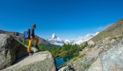 Hiker stands on rocks and looks into the distance