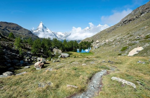 Hiking trail with view of Lake Grindij and snow-covered Matterhorn