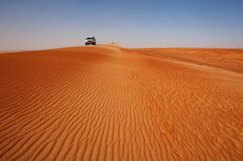 Off-road vehicle and tourist on a sand dunes