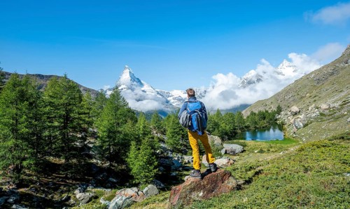 Hiker stands on rocks and looks into the distance