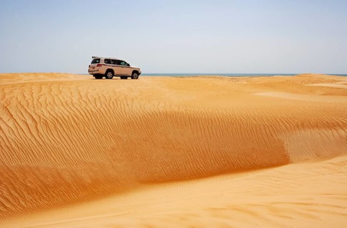 Off-road vehicle drives on sand dune