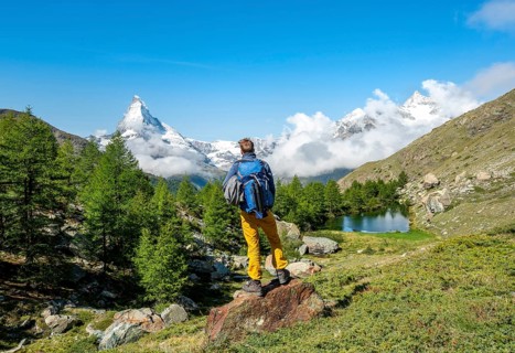 Hiker stands on rocks and looks into the distance