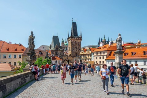 Many tourists walk across Charles Bridge